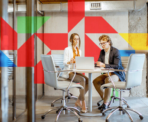 two people having a conversation at a table with red, blue, green, and yellow trapezoids.