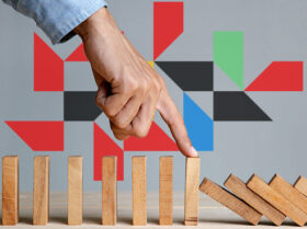 a person stoping a domino train