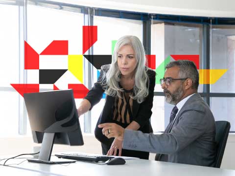 Man and woman working in a desktop computer